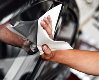 Mechanic cleaning a car window